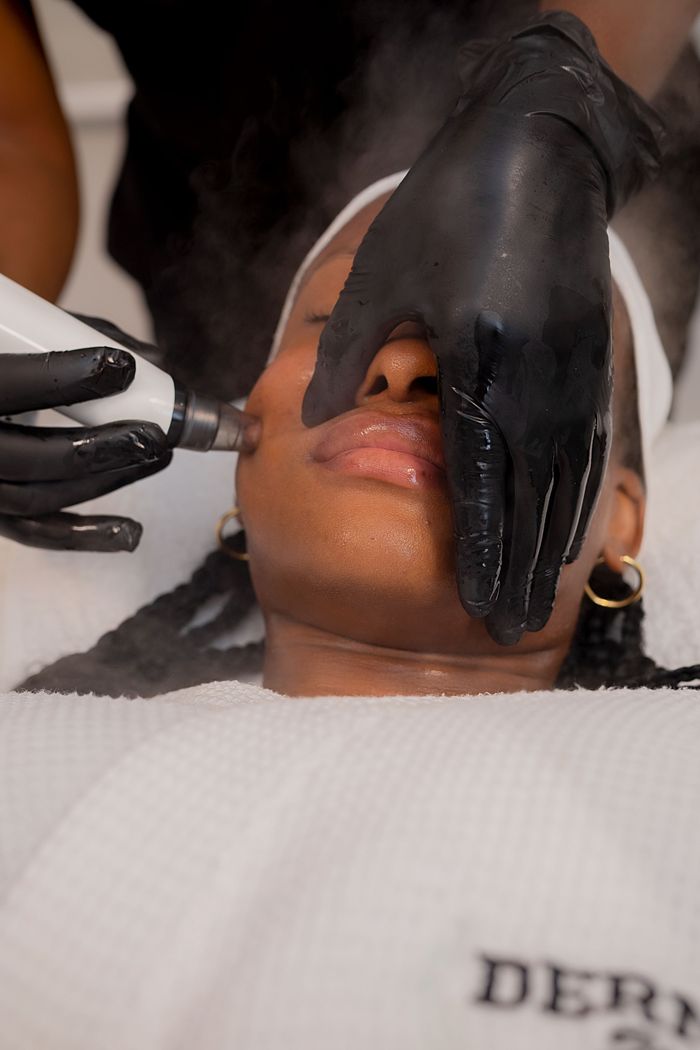 Close-up of a woman receiving a facial treatment in a Nigerian skincare clinic.